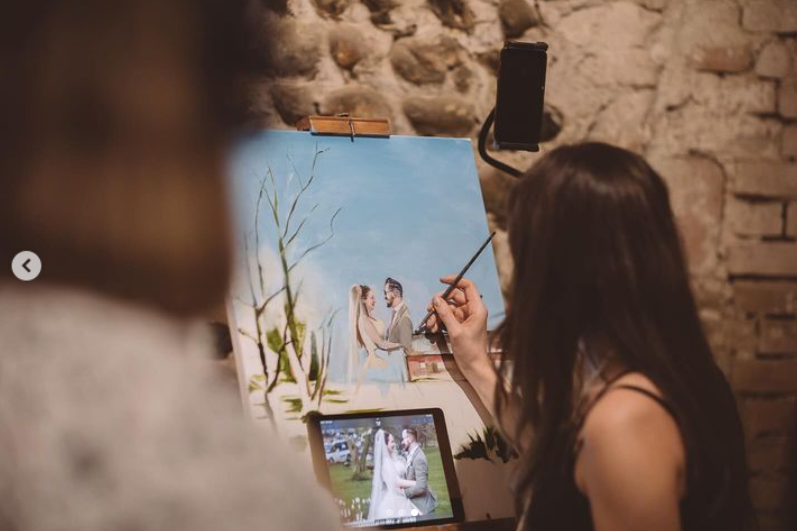 Wedding artist painting live portrait of couple at ceremony - professional wedding painting services UK