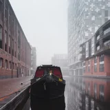 A narrowboat beside Birmingham's canals and brick warehouses