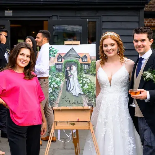 A couple and their artist stand beside a painting inspired by their wedding venue.