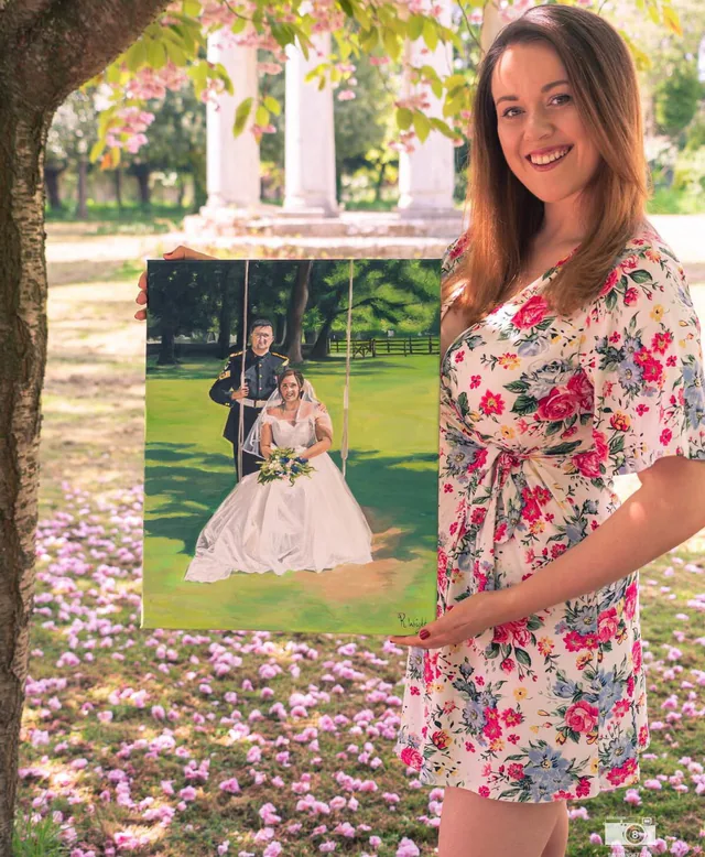 Artist in a garden holding a painted bridal portrait