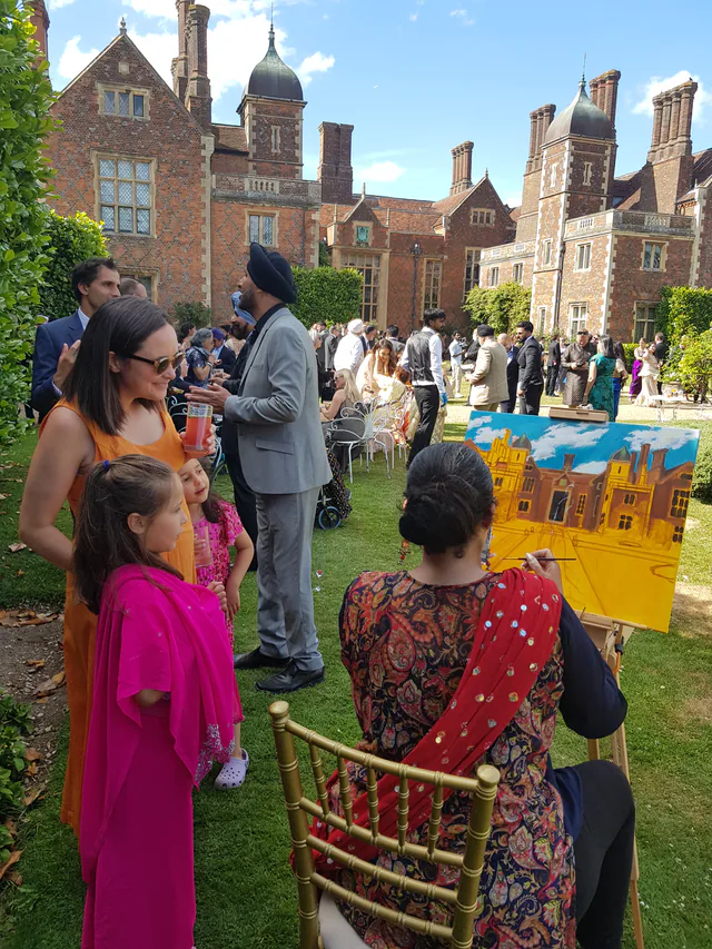 Live wedding artist painting among guests at an outdoor reception