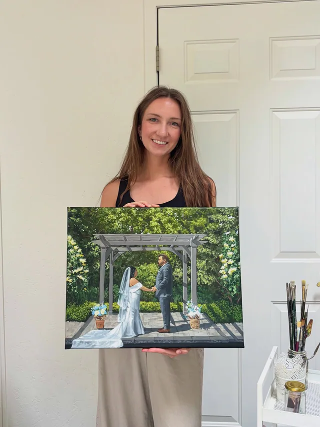 Wedding artist holding a finished garden ceremony painting