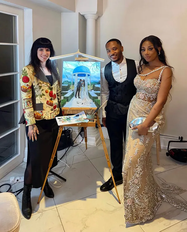Artist and newlyweds beside a painted gazebo wedding scene