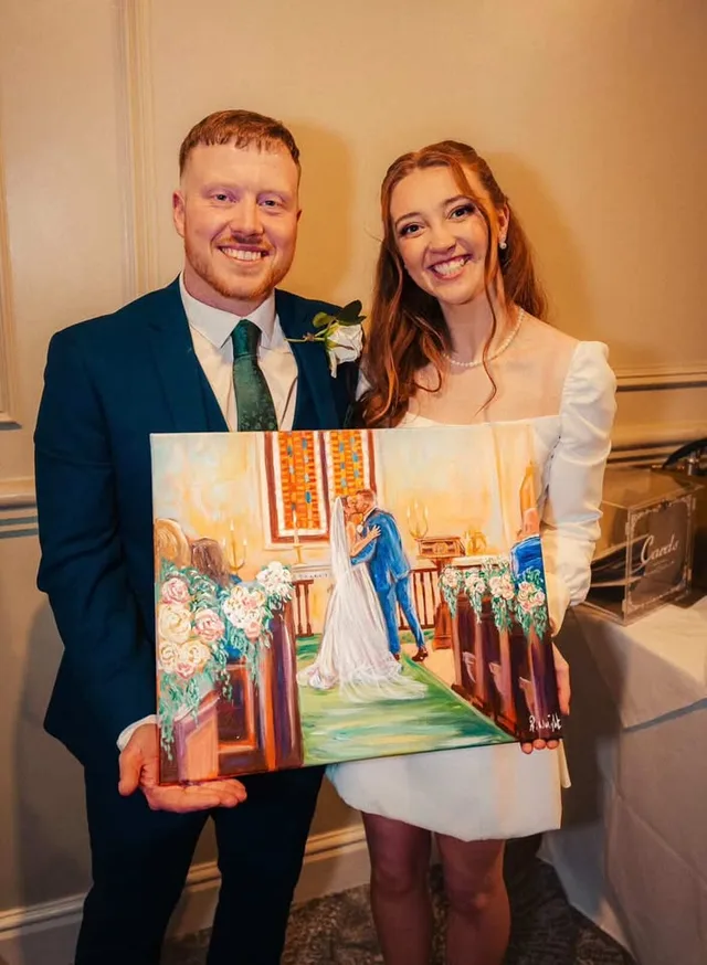 Newlyweds holding their finished painted wedding ceremony portrait